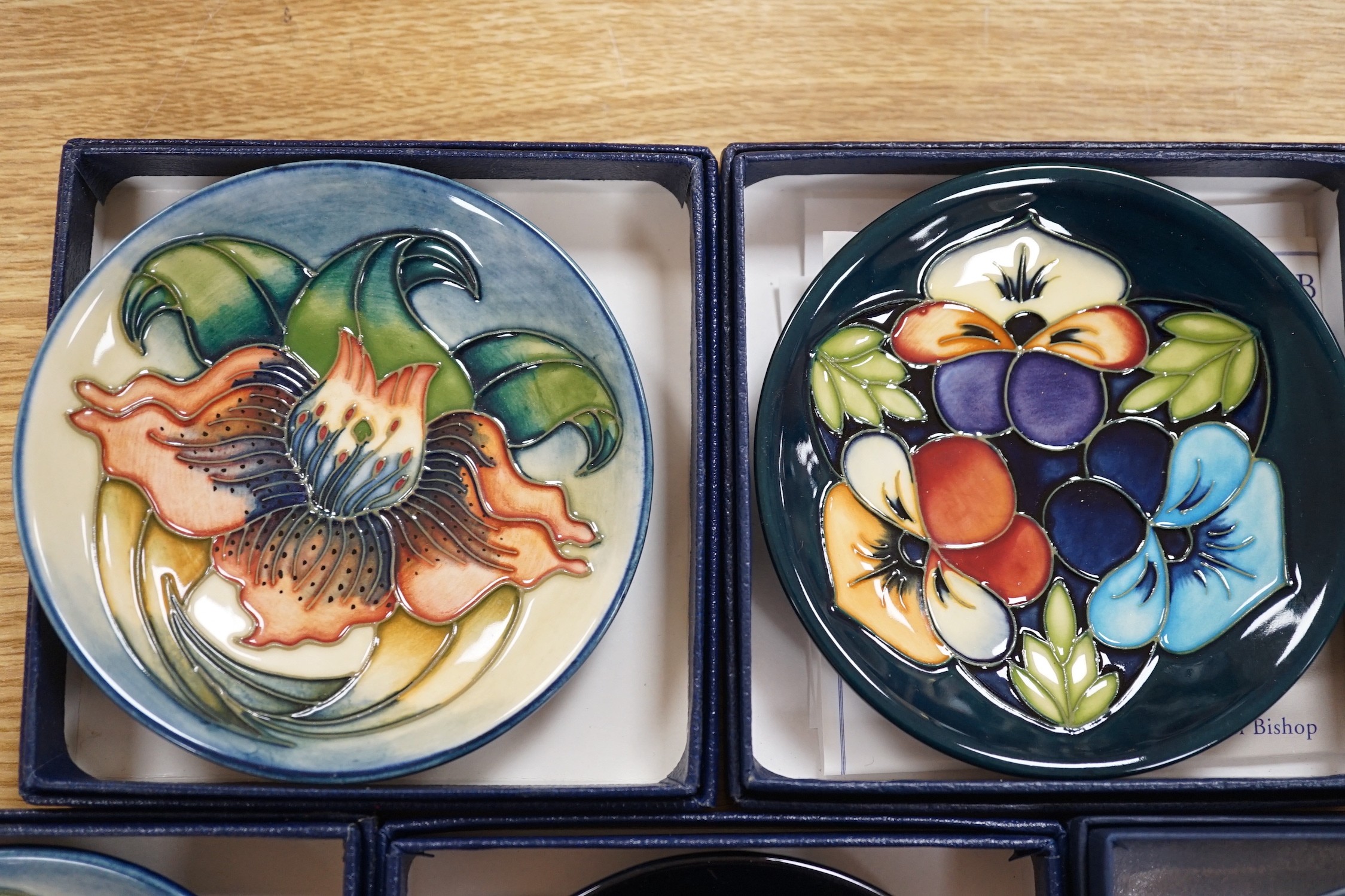 Six boxed Moorcroft pin dishes, A Woodside Farm, Panache, Simeon, Triple Choice, and Anna Lily. Each 11.5cm diameter